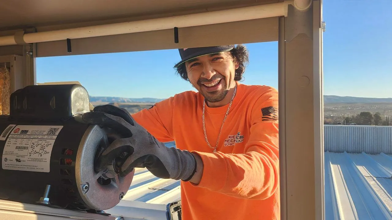 Nichols technician holding a blower motor during a rooftop HVAC repair