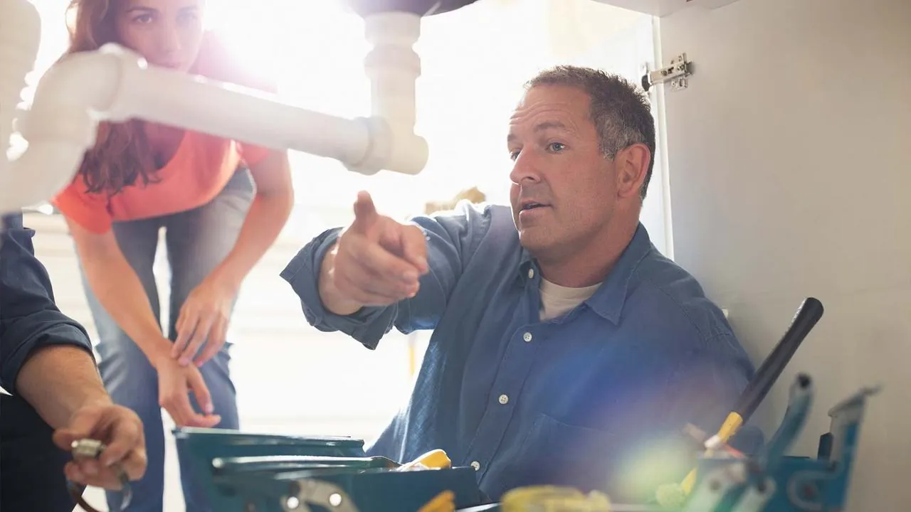 Plumber explaining a sink repair to a homeowner