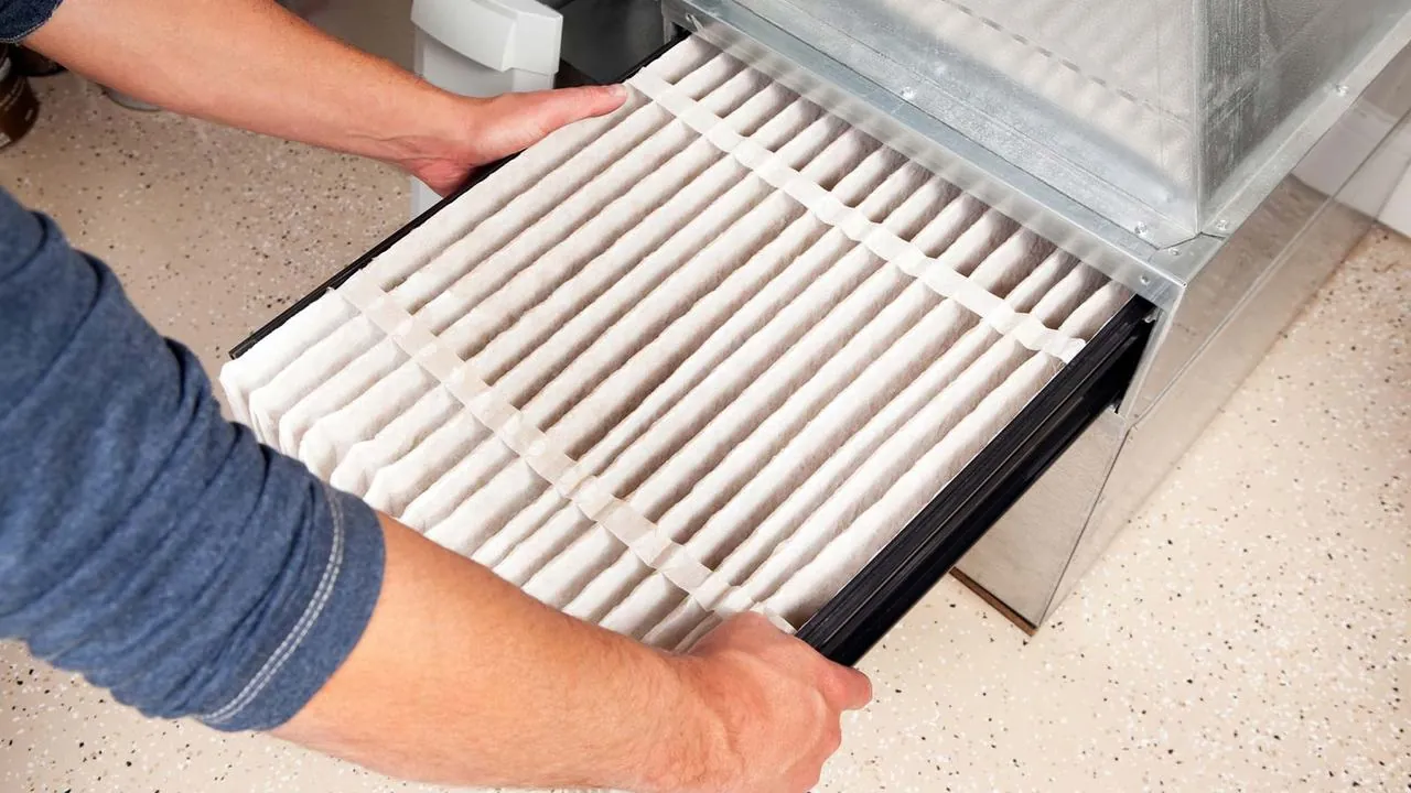 Sliding a new air filter into an HVAC system