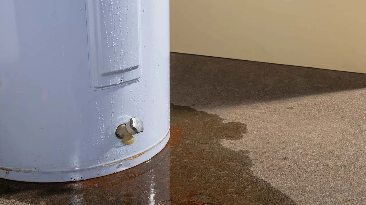Puddle of water spreading around the base of a water heater