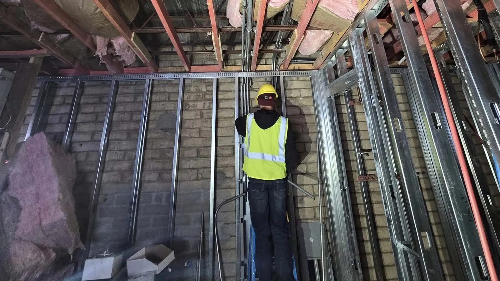 Electrician working in a commercial build-out with steel studs