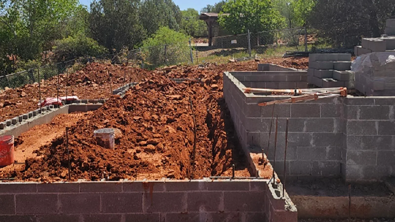 Plumbing trench dug inside a new block foundation