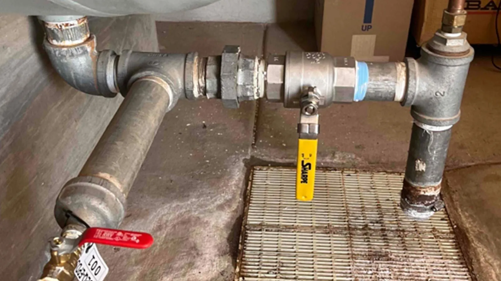 New threaded pipe and shutoff valves above a floor drain