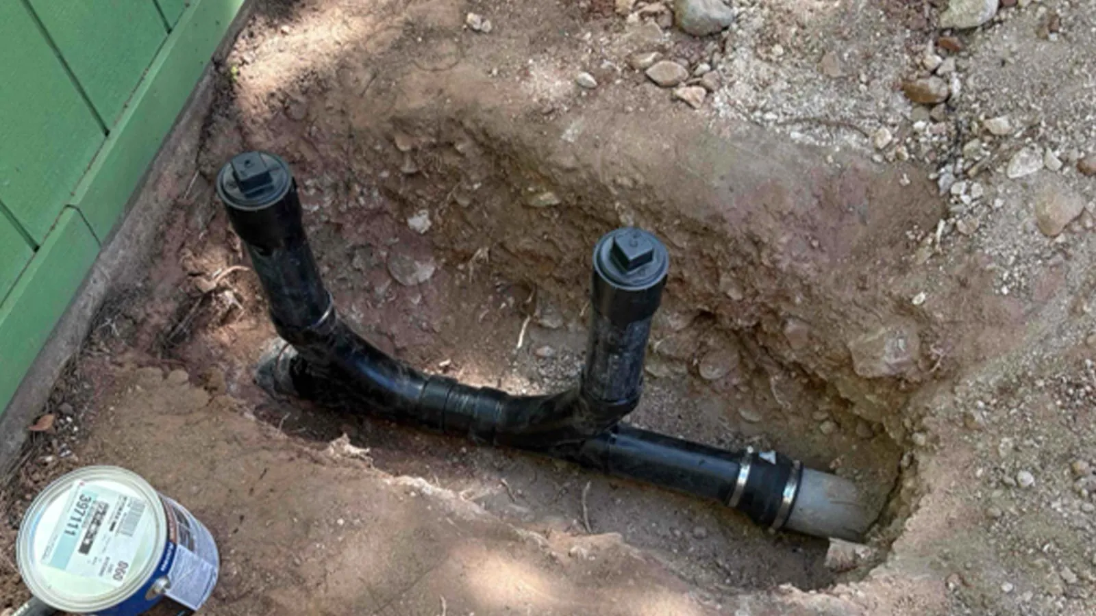 New two-way sewer cleanout installed in an excavated hole