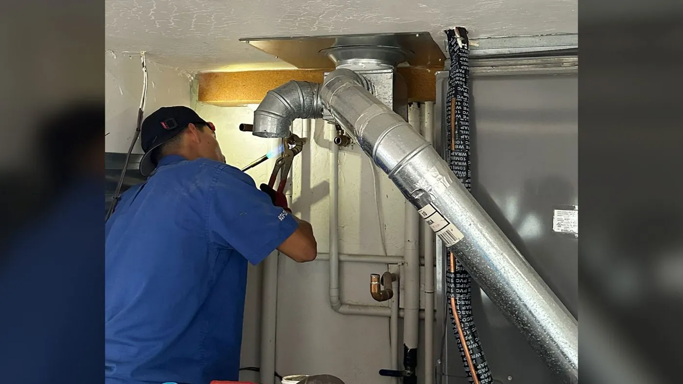 Nichols technician installing a furnace flue pipe