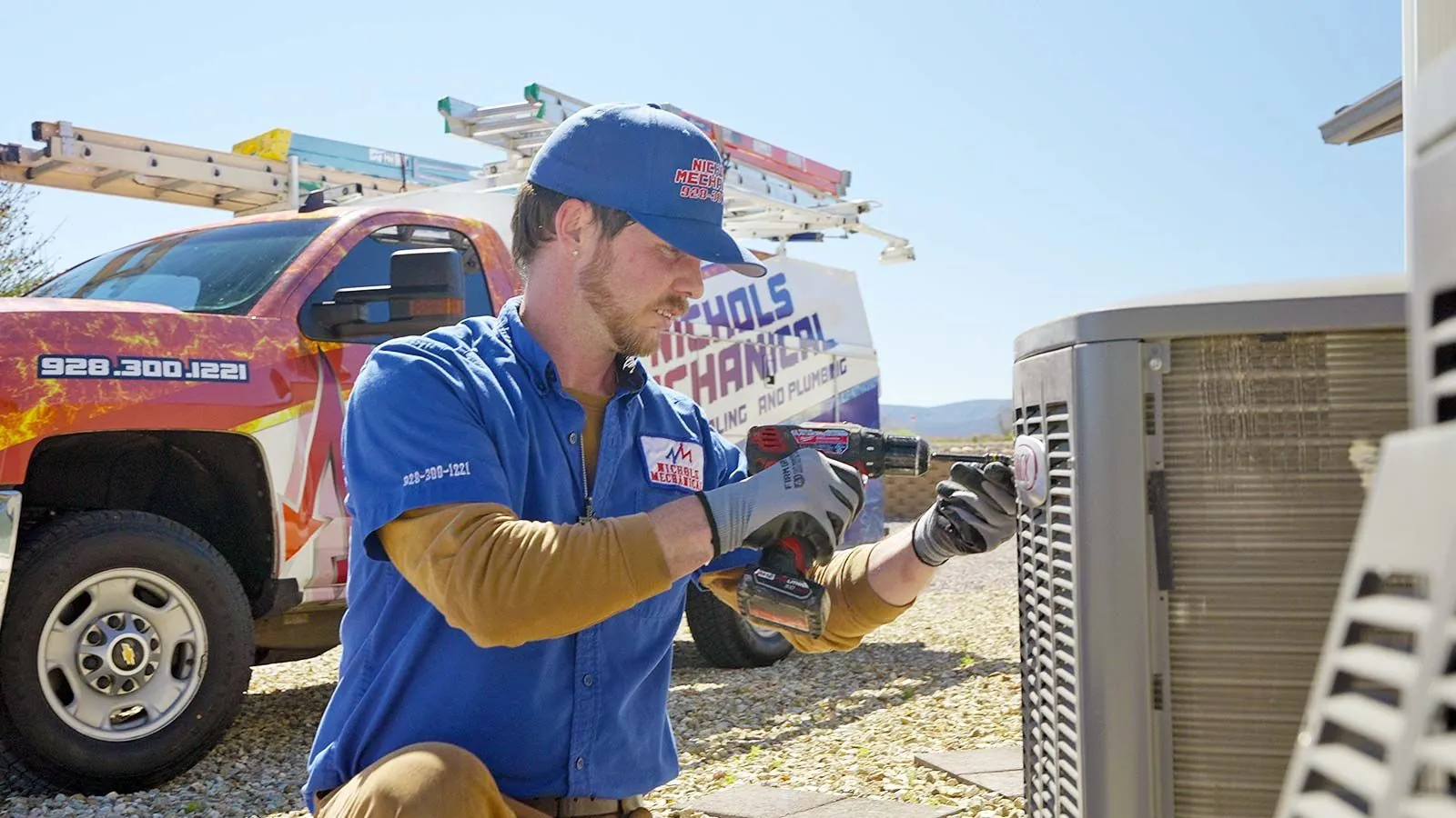 Nichols technician repairing an AC condenser with a drill