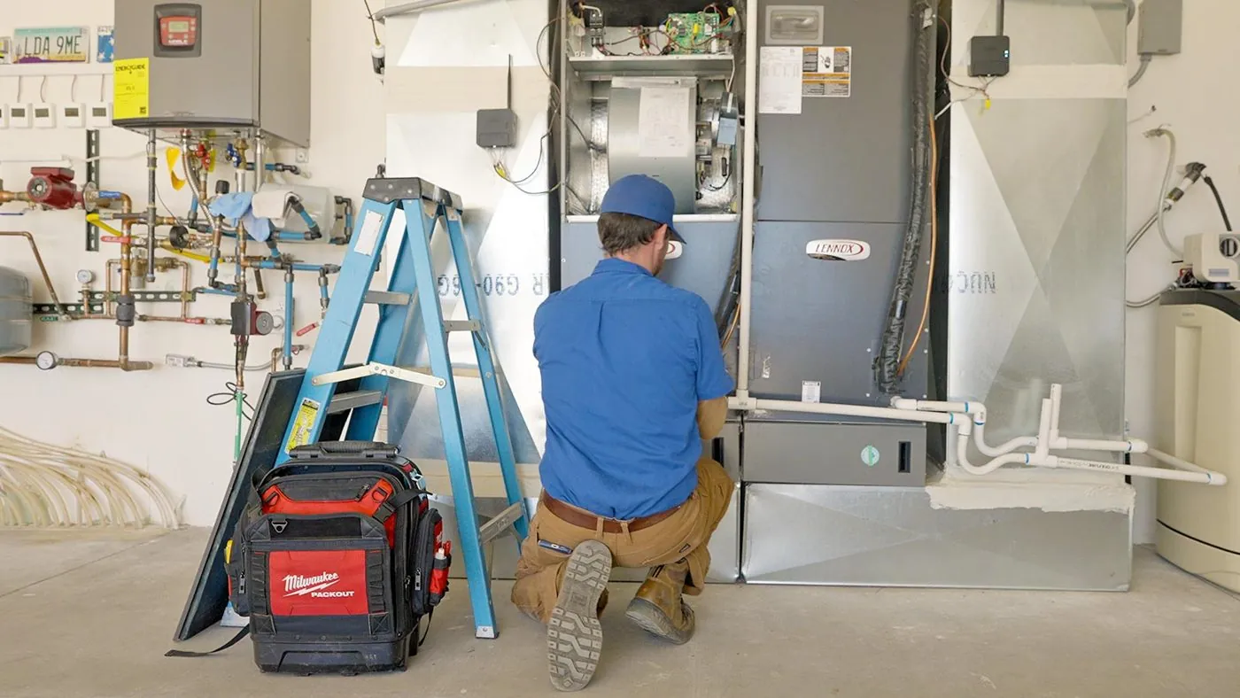 Nichols technician servicing a furnace and air handler in a garage