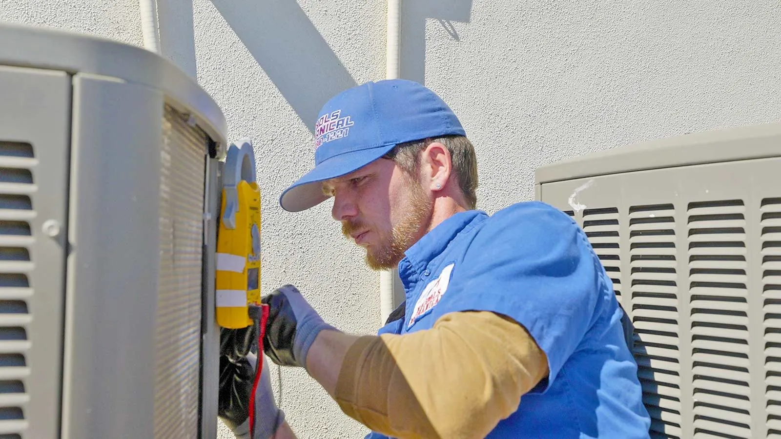 Nichols technician testing AC condenser wiring with a multimeter