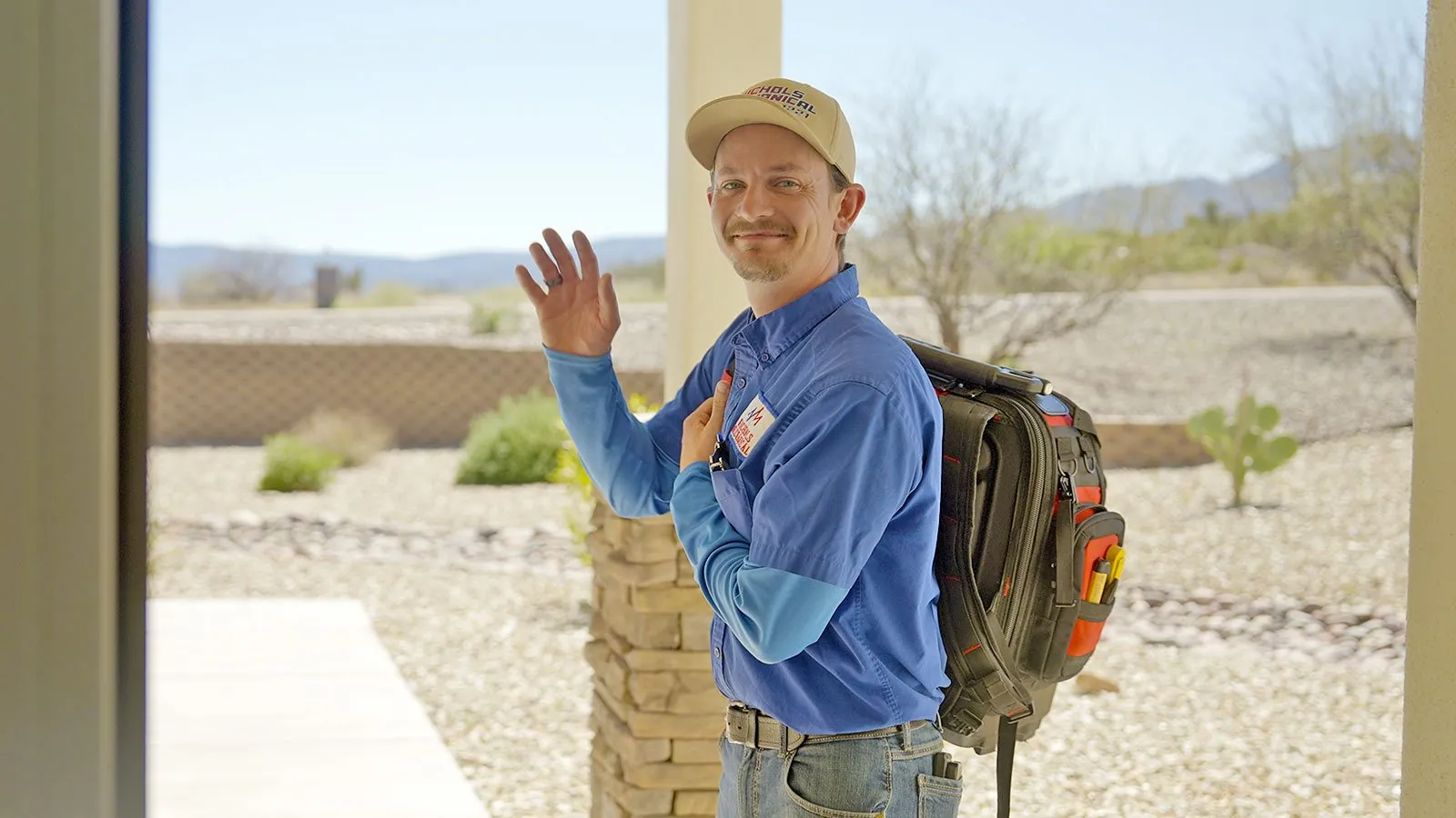Nichols technician waving at a customer's front door