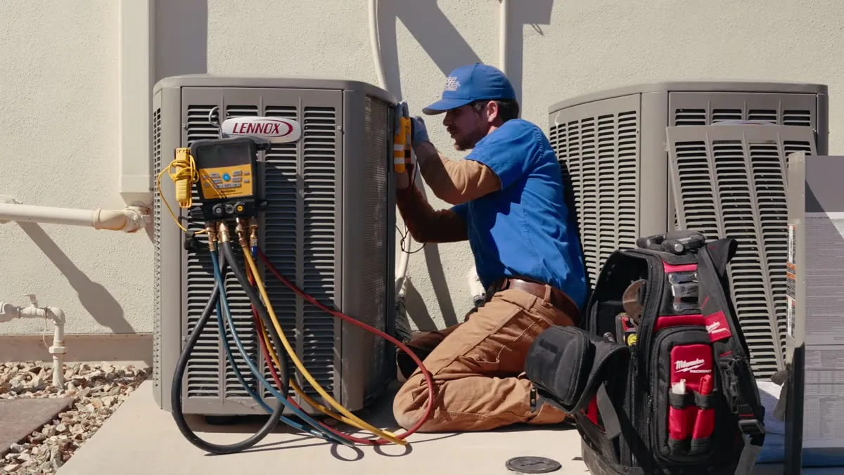 Nichols technician checking an AC condenser with gauges